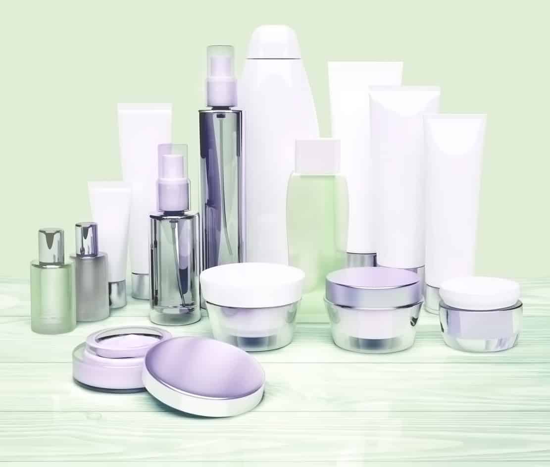Cosmetic containers located on a white wooden background